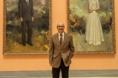 Miguel Romero con los cuadros de los Reyes Eméritos